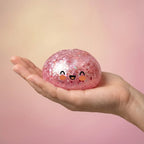 Squishy Dumpling Rose Bubblegum Pailleté — tenu dans la main