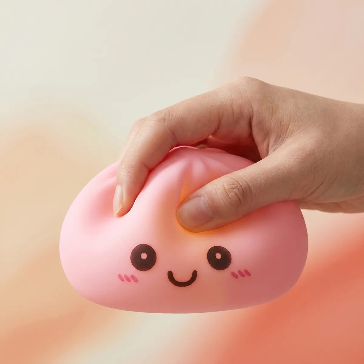 Veilleuse Squishy Dumpling Rose — pressée entre les doigts