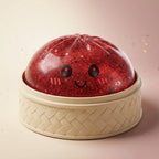 Squishy Dumpling Rouge à Paillettes — posé dans son panier vapeur en bambou