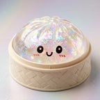 Squishy Dumpling Argenté à Paillettes — posé dans son panier vapeur en bambou