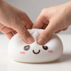 Veilleuse Squishy Dumpling Blanche — pressée entre les doigts